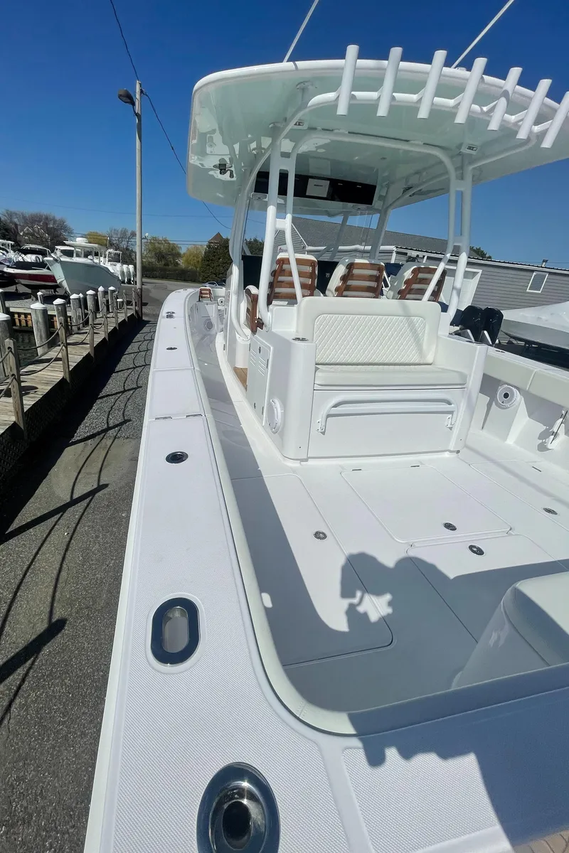 Slide: The Image of 2023 Jupiter 40 boat docked, showcasing spacious deck and seating. - 11