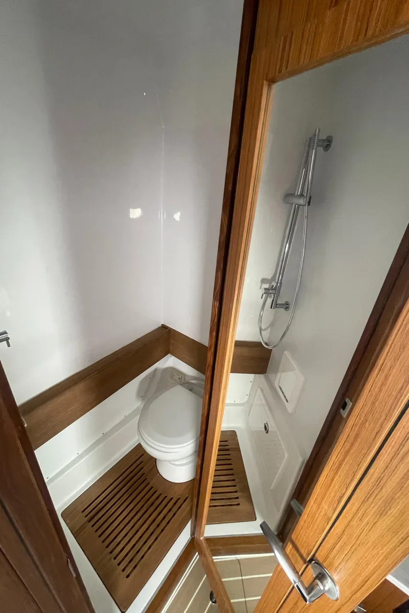 Slide: The Image of Compact bathroom with wooden accents in a 2023 Jupiter 40 model boat. - 23