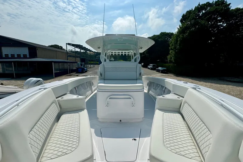 Slide: The Image of 2023 Jupiter 40 boat interior with white seating and open deck under a clear sky. - 48