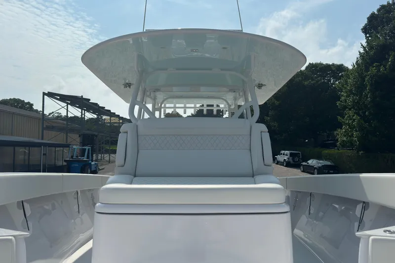 Slide: The Image of 2023 Jupiter 40 boat with sleek white seating and canopy, docked outdoors. - 51