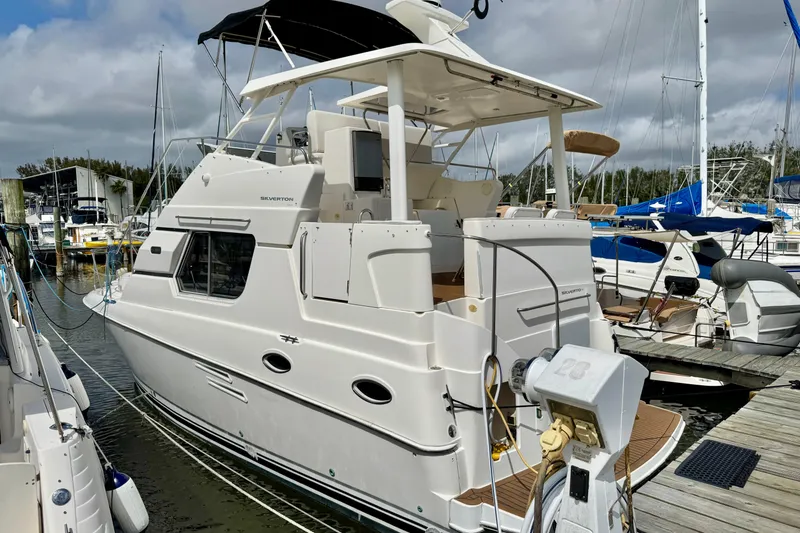 The Image of 2000 Silverton 322 Motor Yacht docked at marina under cloudy sky. - 0