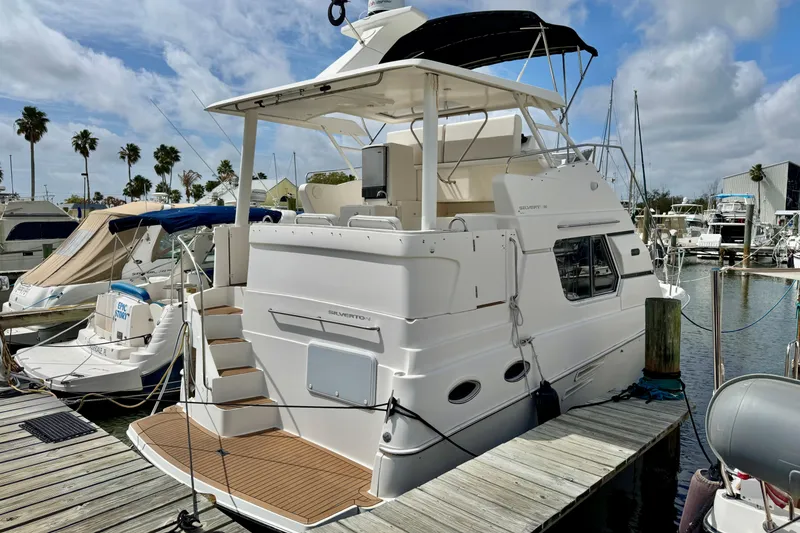 Slide: The Image of 2000 Silverton 322 Motor Yacht docked at marina under blue sky. - 1