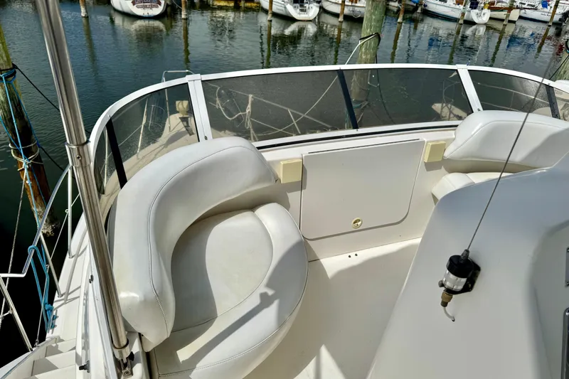 Slide: The Image of 2000 Silverton 322 Motor Yacht deck with white seating, docked at marina. - 12