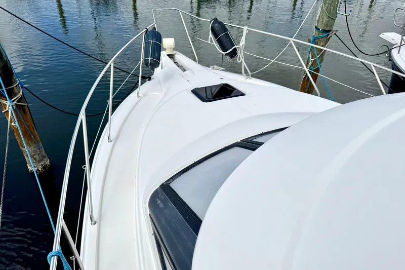 Slide: The Image of 2000 Silverton 322 Motor Yacht docked, showcasing sleek deck design and railing. - 18