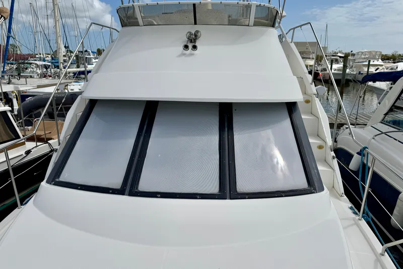 Slide: The Image of 2000 Silverton 322 Motor Yacht docked at marina, showcasing front windows and deck. - 23