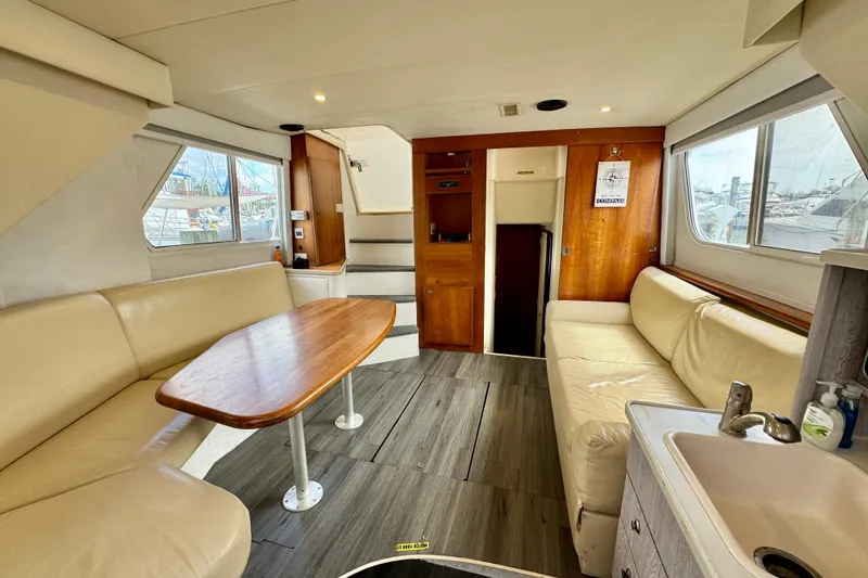 Slide: The Image of Interior of 2000 Silverton 322 Motor Yacht with beige seating and wooden table. - 24
