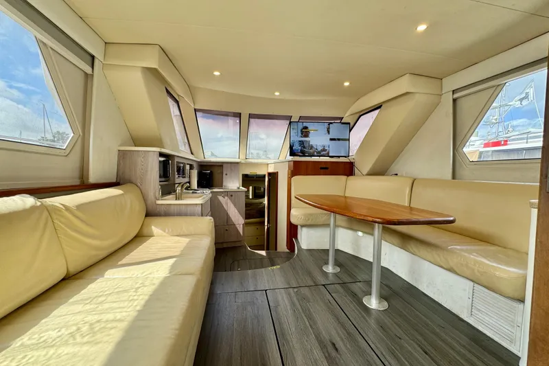 Slide: The Image of Interior of 2000 Silverton 322 Motor Yacht with beige seating and wooden table. - 26