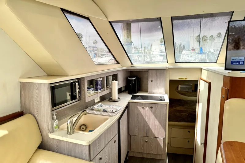 Slide: The Image of Interior of 2000 Silverton 322 Motor Yacht with kitchenette and large windows. - 27