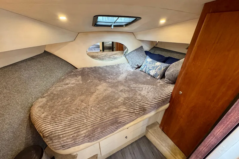 Slide: The Image of Cozy bedroom in 2000 Silverton 322 Motor Yacht with plush bedding and wooden accents. - 28