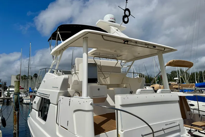 Slide: The Image of 2000 Silverton 322 Motor Yacht docked at marina under cloudy sky. - 3