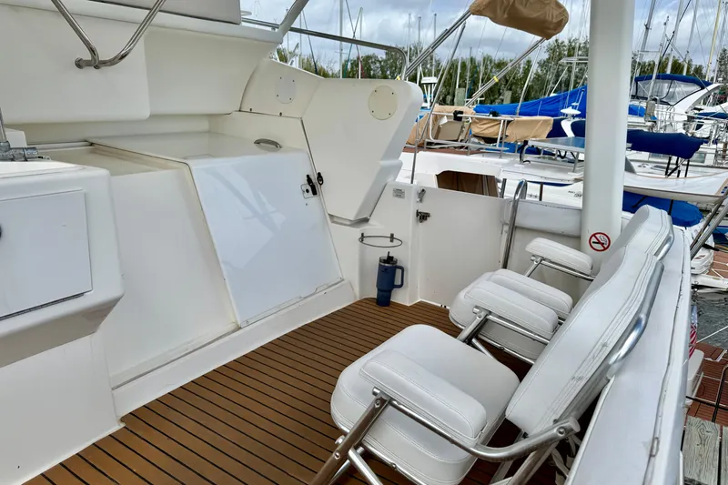 Slide: The Image of 2000 Silverton 322 Motor Yacht deck with white seating and wood flooring. - 5