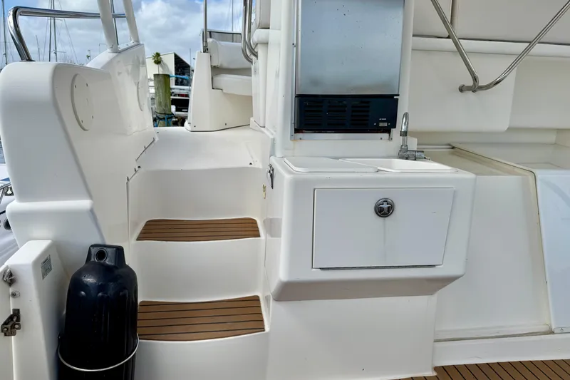 Slide: The Image of 2000 Silverton 322 Motor Yacht deck with steps, sink, and storage compartment. - 6