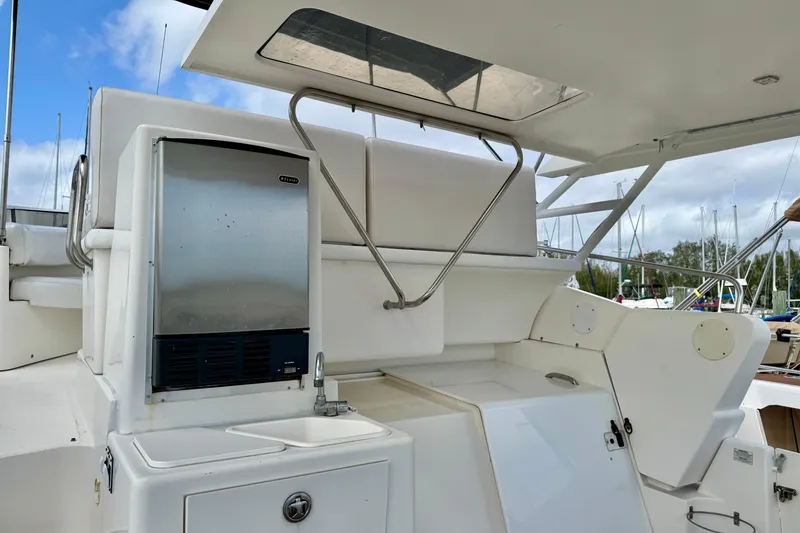 Slide: The Image of 2000 Silverton 322 Motor Yacht deck with sink and storage, marina background. - 7