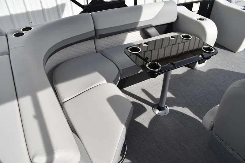Slide: The Image of Luxurious seating area on 2026 Lowe SS 210 pontoon boat with sleek table and cup holders. - 10
