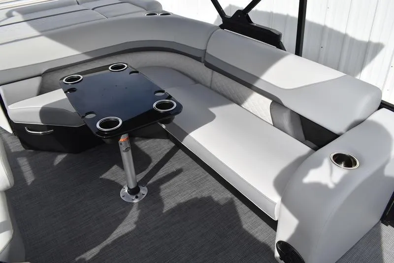 Slide: The Image of 2026 Lowe SS 210 boat interior with gray seating and black table with cup holders. - 13