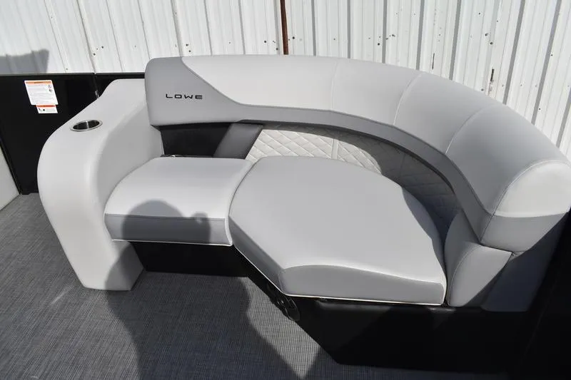 Slide: The Image of 2026 Lowe SS 210 boat seating with gray upholstery and cup holder, against a metal backdrop. - 6
