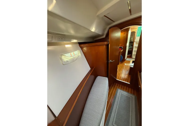 Slide: The Image of Interior of 2001 Beneteau 393 sailboat, featuring wooden finishes and cozy seating area. - 11