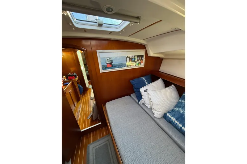 Slide: The Image of Interior of 2001 Beneteau 393 yacht cabin with cozy seating and decorative pillows. - 13