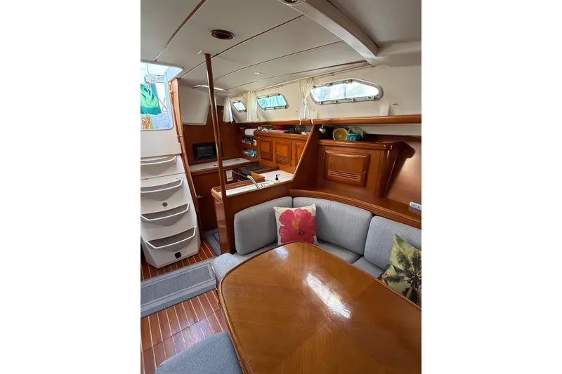 Slide: The Image of Interior of 2001 Beneteau 393 sailboat with cozy seating and wooden cabinetry. - 15