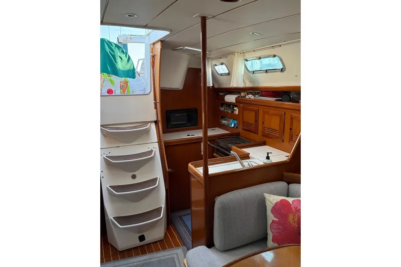 Slide: The Image of Interior of 2001 Beneteau 393 sailboat with wooden cabinetry and cozy seating area. - 16