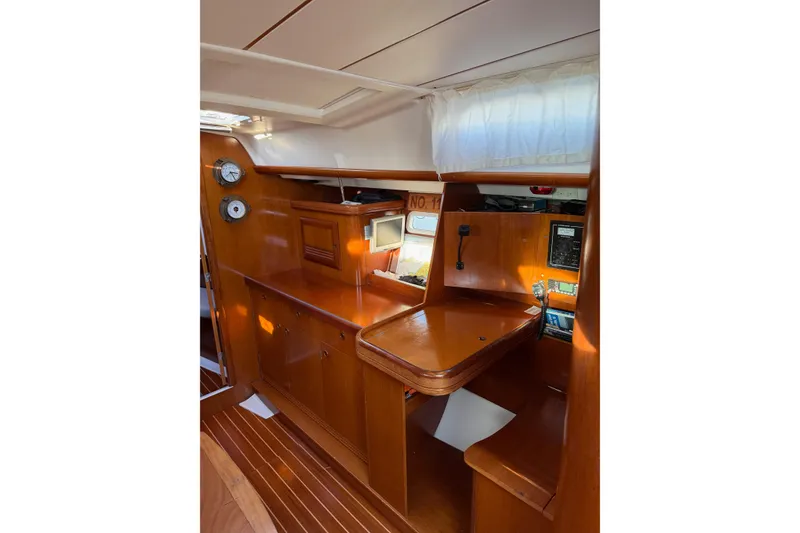 Slide: The Image of Interior of 2001 Beneteau 393 sailboat with wooden cabinetry and navigation station. - 18