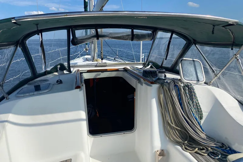 Slide: The Image of Cockpit view of 2001 Beneteau 393 sailboat with ropes and ocean backdrop. - 6
