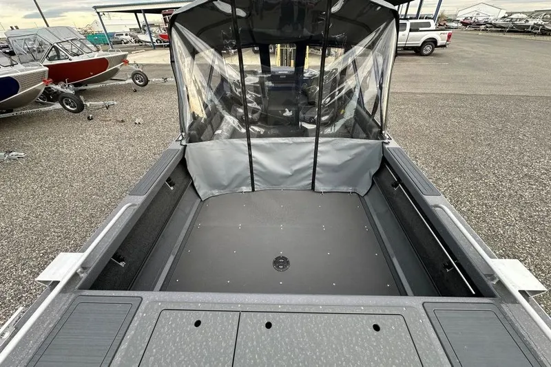 Slide: The Image of 2026 Weldcraft 200 Rebel boat interior with canopy, parked in a lot. - 5