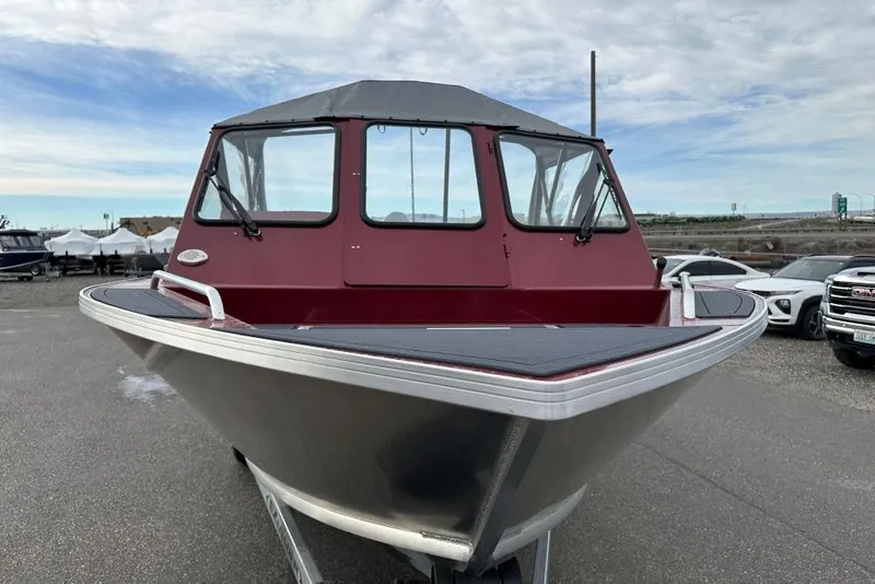 Slide: The Image of 2026 Weldcraft 210 Revolution boat with red cabin, parked outdoors. - 3