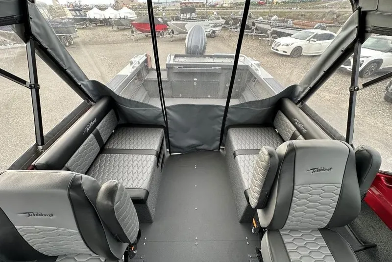 Slide: The Image of Interior of 2026 Weldcraft 210 Revolution boat with gray seating and protective canopy. - 5