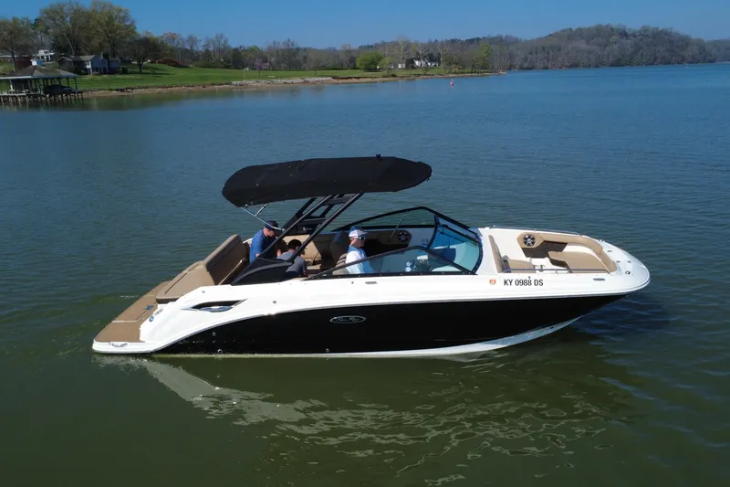 Slide: The Image of 2023 Sea Ray SDX 250 boat cruising on a serene lake with passengers onboard. - 14
