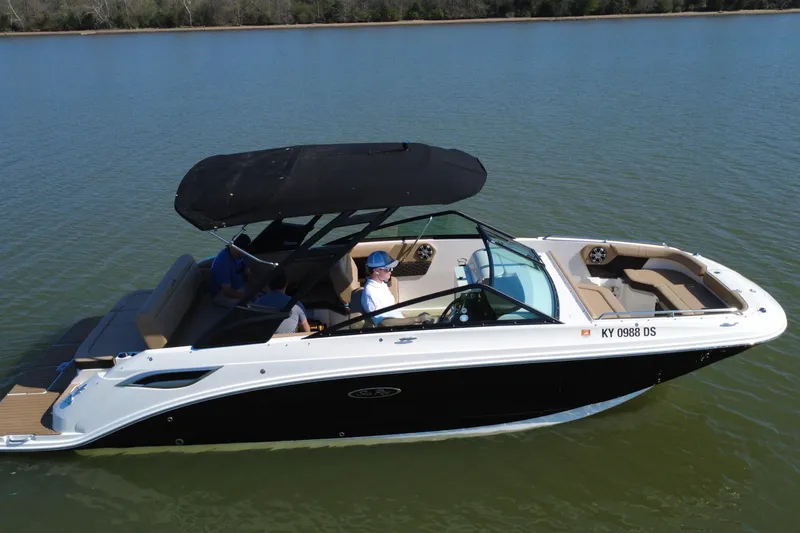 Slide: The Image of 2023 Sea Ray SDX 250 boat cruising on a calm lake with passengers onboard. - 17