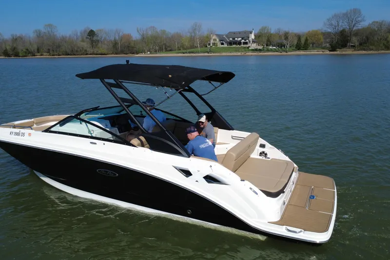 Slide: The Image of 2023 Sea Ray SDX 250 boat cruising on a serene lake with passengers onboard. - 19
