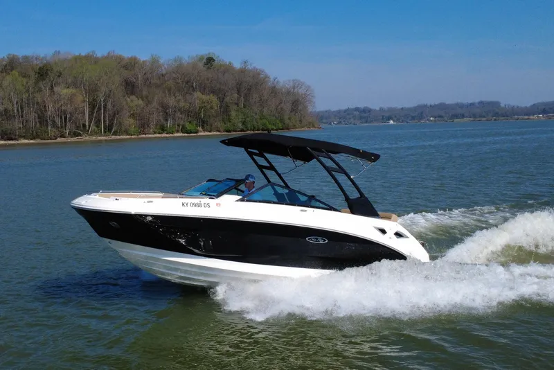 Slide: The Image of 2023 Sea Ray SDX 250 cruising on a scenic lake with lush forest backdrop. - 21