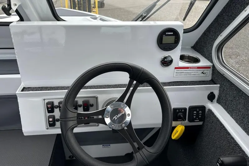 Slide: The Image of 2026 Weldcraft 220 Maverick boat dashboard with steering wheel and control panel. - 9