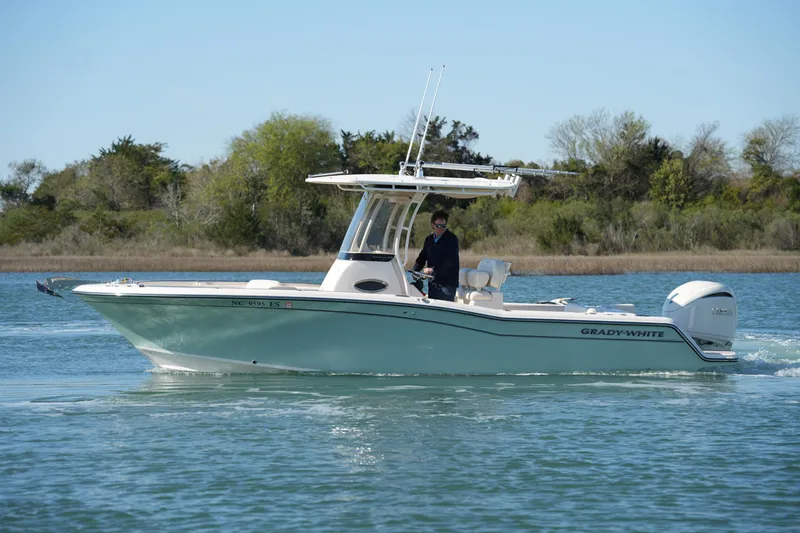 Slide: The Image of 2021 Grady-White Fisherman 236 boat cruising on a calm lake with lush greenery. - 10