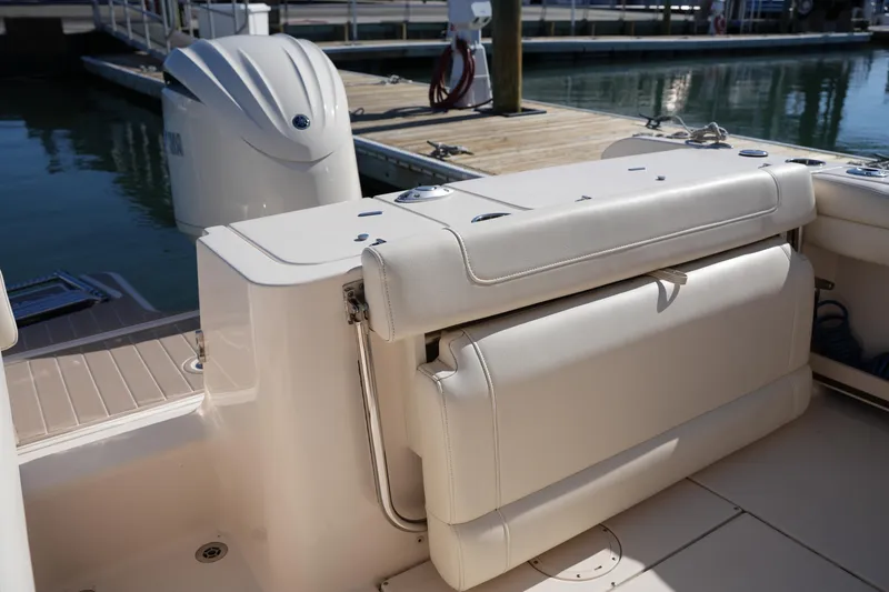 Slide: The Image of 2021 Grady-White Fisherman 236 boat interior with cushioned seating and motor at dock. - 12