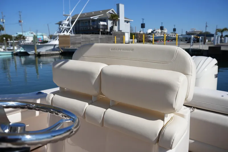 Slide: The Image of 2021 Grady-White Fisherman 236 boat interior with steering wheel and cushioned seating. - 16