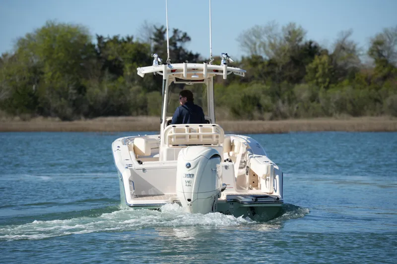 Slide: The Image of 2021 Grady-White Fisherman 236 boat cruising on a calm lake with trees in the background. - 7