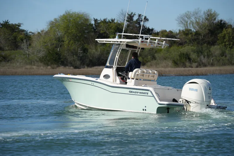 Slide: The Image of 2021 Grady-White Fisherman 236 boat cruising on a serene lake with lush greenery. - 9