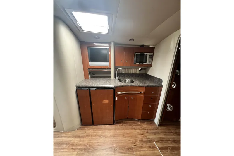 Slide: The Image of Interior of 2006 Formula 40 Performance Cruiser with kitchenette, wood cabinets, and appliances. - 17