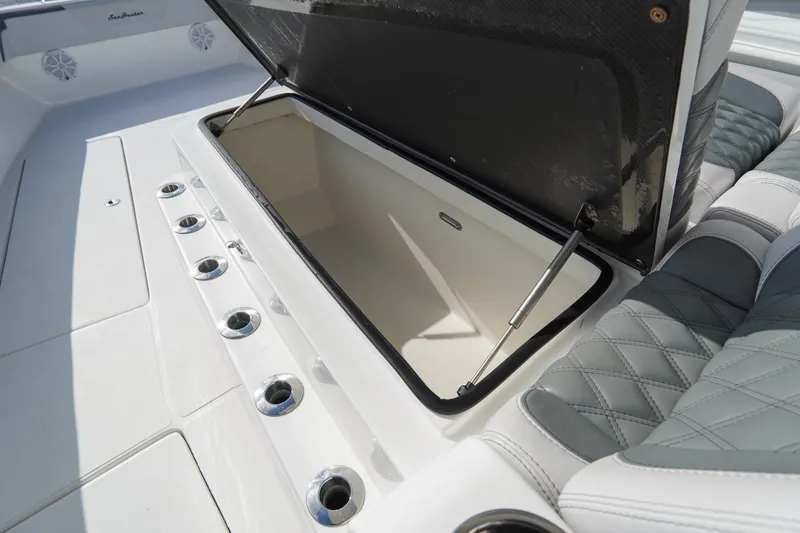 Slide: The Image of 2022 SeaHunter 41 CTS boat with open storage compartment and rod holders. - 26