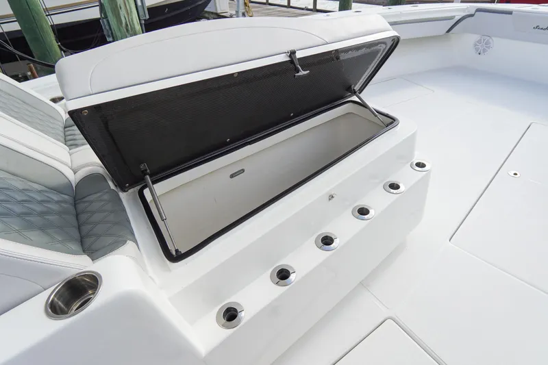 Slide: The Image of Open storage compartment on 2022 SeaHunter 41 CTS boat deck with rod holders. - 27