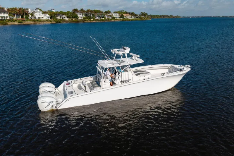 Slide: The Image of 2022 SeaHunter 41 CTS boat on calm water, with coastal homes in the background. - 4