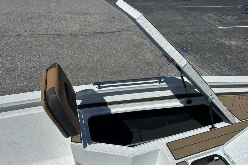 Slide: The Image of 2026 Xpress XR21 Bay boat with open storage compartment and cushioned seat. - 16