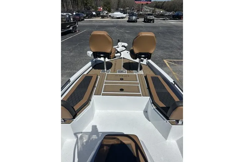 Slide: The Image of 2026 Xpress XR21 Bay boat interior with tan seating and deck, parked outdoors. - 9