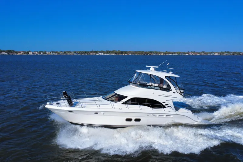 The Image of 2005 Sea Ray 500 Sedan Bridge cruising on open water under clear blue skies. - 0