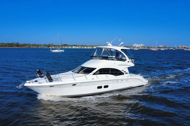 Slide: The Image of 2005 Sea Ray 500 Sedan Bridge yacht cruising on open water under clear blue sky. - 10