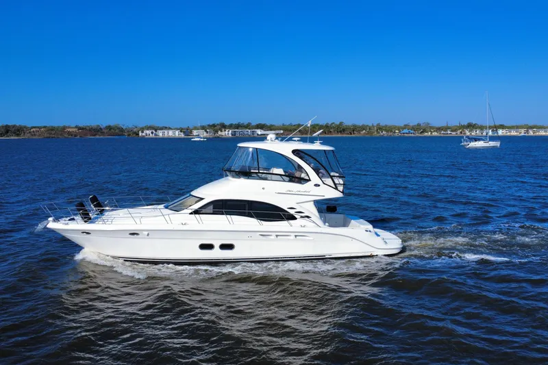 Slide: The Image of 2005 Sea Ray 500 Sedan Bridge yacht cruising on open water under clear blue skies. - 11