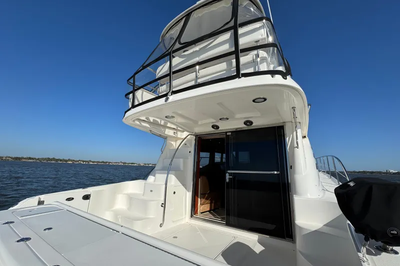 Slide: The Image of 2005 Sea Ray 500 Sedan Bridge yacht on open water, showcasing upper deck and cabin entrance. - 16