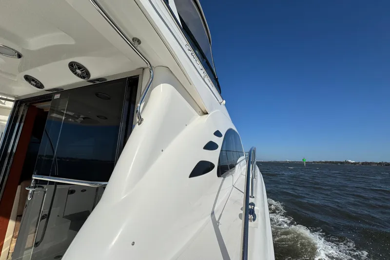 Slide: The Image of 2005 Sea Ray 500 Sedan Bridge yacht cruising on open water under clear blue sky. - 21